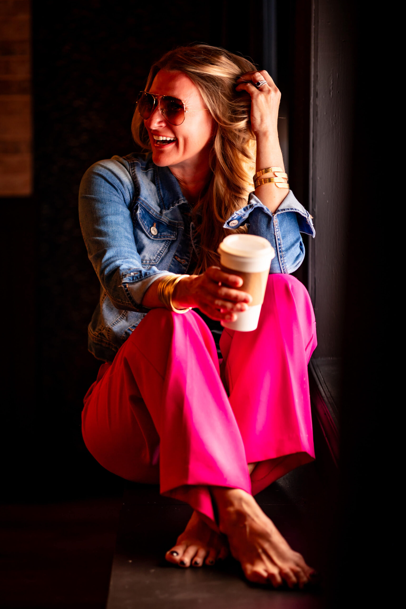 Callie Croken, a life and business coach, sipping coffee playfully in a window sill during her branding photoshoot with Lake Design.